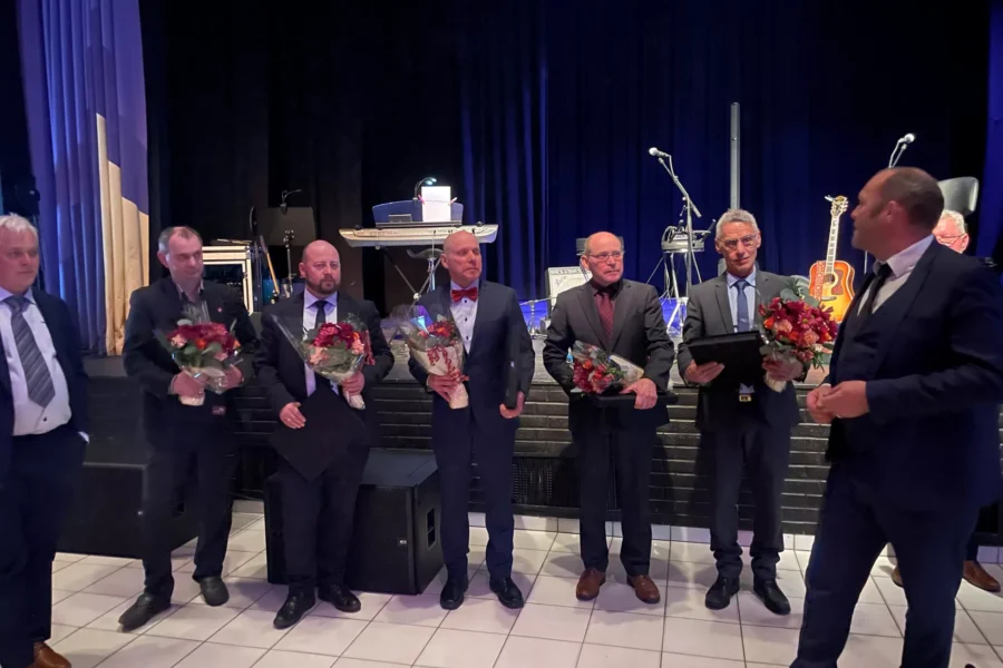 Charles Bøe, Audun Hopen, Svein Neerland, Olav Neerland og Arve Trones (med blomsterbuketter) fikk utdelt hedersmedalje.